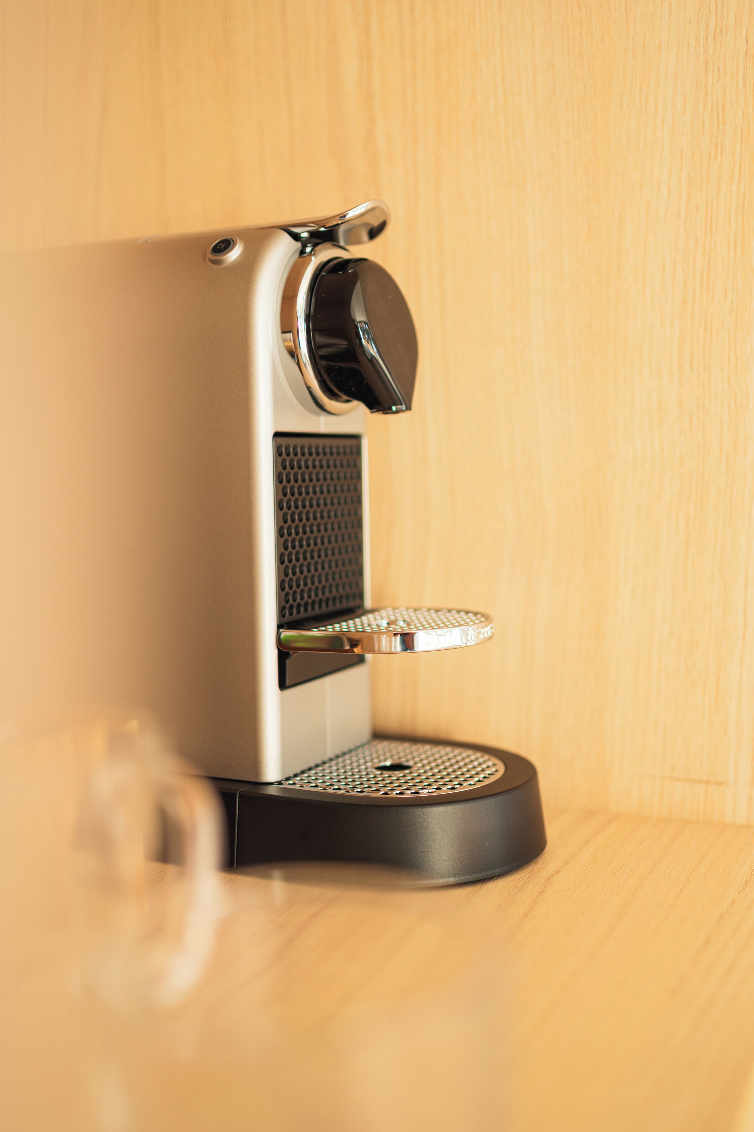 Una máquina de café con panel de control, bandeja de goteo y depósito de agua.