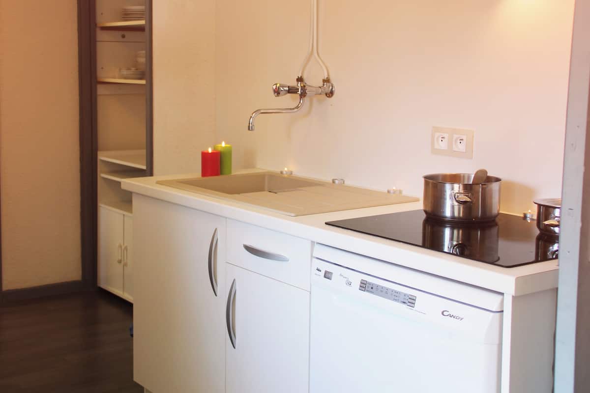 Una cucina dotata di lavastoviglie, lavello, fornello e pensile.