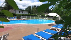 Ein Swimmingpool mit Liegestühlen und einem Gebäude im Hintergrund.