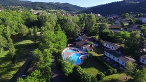A residential area with a swimming pool surrounded by lush greenery and houses. - VVF Les Gorges de l'Allier, Lavoûte Chilhac (Lavoute-Chilhac)