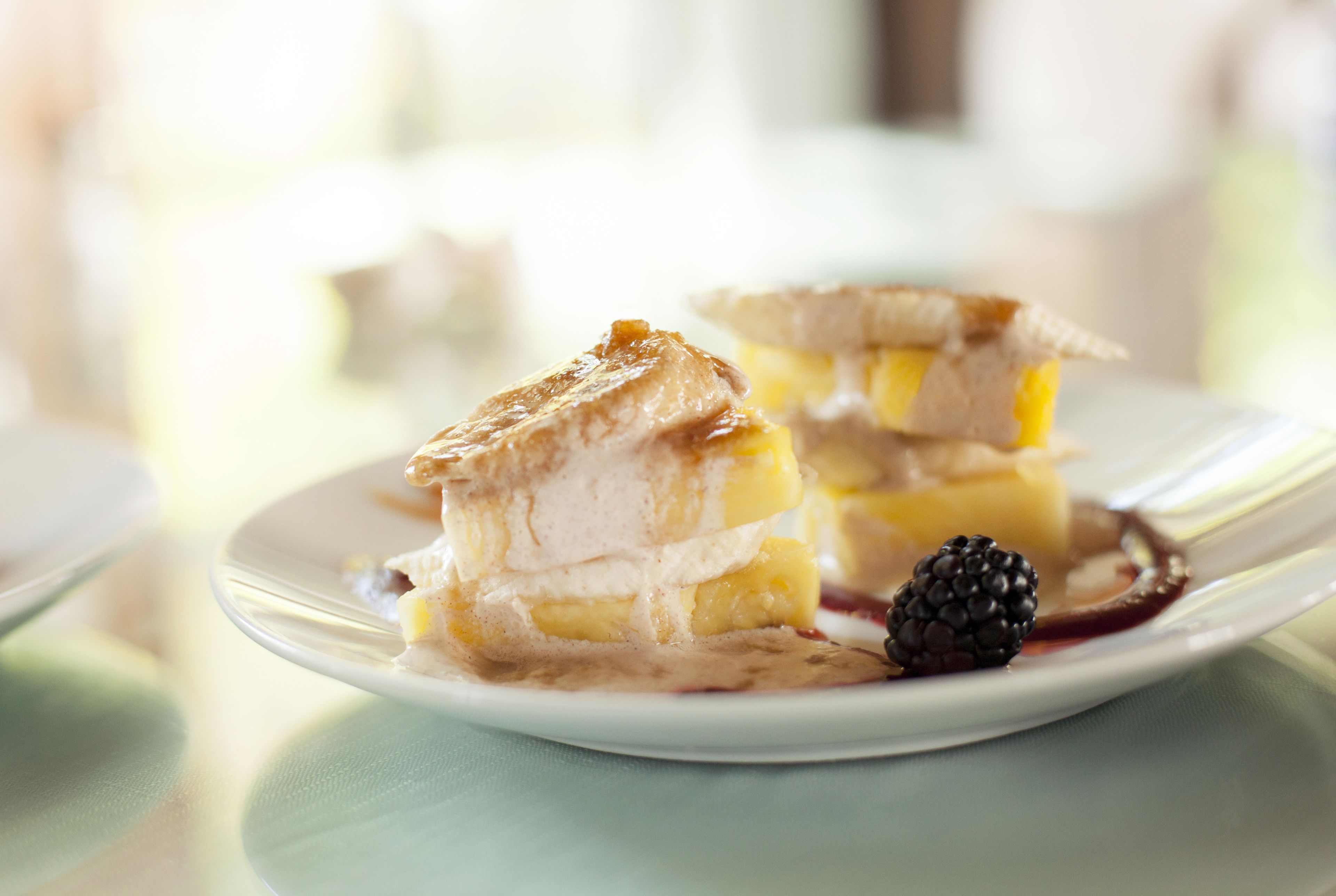 Un dessert servi dans une assiette, accompagné de mûres.