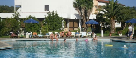 Una piscina al aire libre de temporada, sombrillas