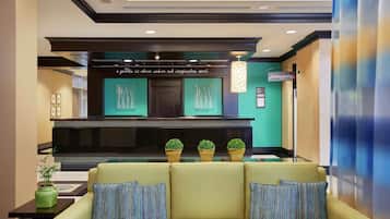 A lobby with a green sofa, a black reception desk, and a sign that reads "a quick it where nature and imagination meet."