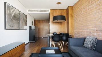 Una sala de estar moderna con un sofá gris, una mesa de centro y un comedor con una mesa y sillas.