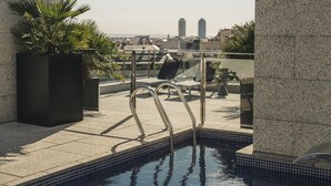 Una piscina en la azotea con vistas despejadas del horizonte urbano.