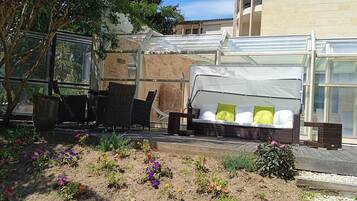 An outdoor seating area with wicker furniture and a covered sofa.