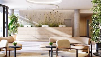 A modern lobby with a reception desk, seating area, and decorative plants.