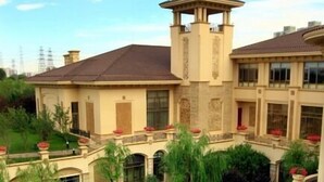 A hotel with a courtyard featuring a water garden, a bridge, and a tower. - Chateau Star River (Beijing)