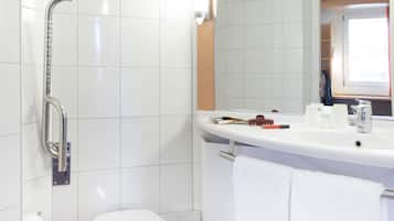 Ein Badezimmer mit Dusche, Toilette, Waschbecken und Handtuchhalter.