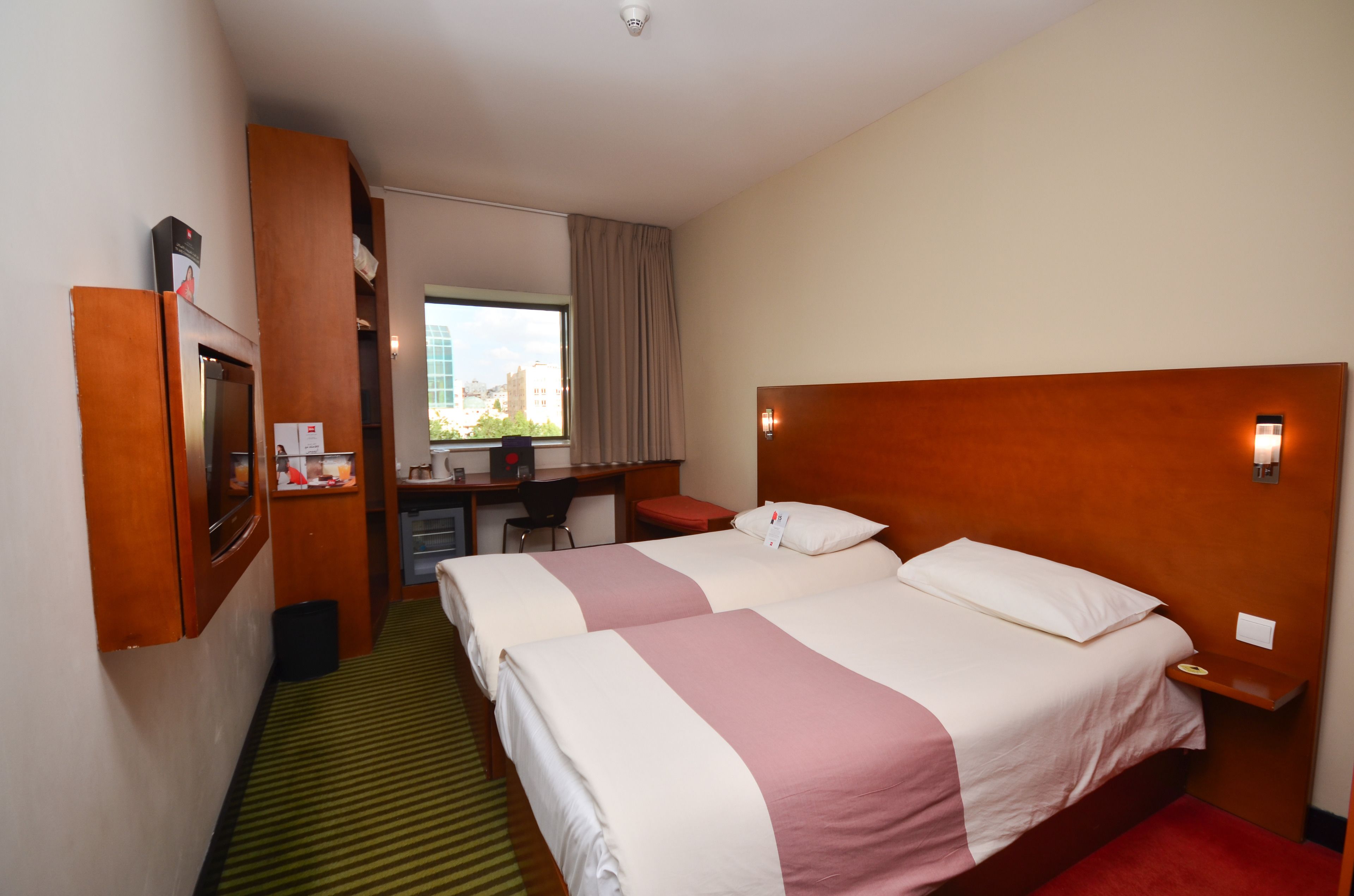 Une chambre d’hôtel avec deux lits, un bureau et une chaise.