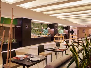 A modern dining area with tables, chairs, and a buffet station. - ibis Amman (Amman)