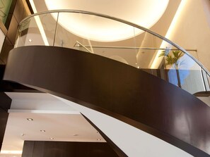 A modern spiral staircase with glass railings and recessed lighting. - ibis Amman (Amman)