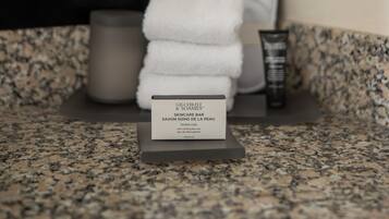 A bathroom counter with a skincare bar, a towel, and a cup.