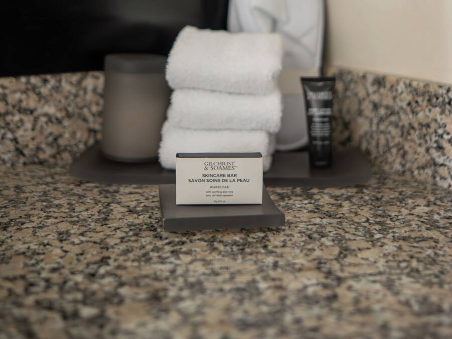 A bathroom counter with a skincare bar, a towel, and a cup.