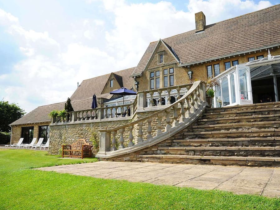 A large stone building with a grand staircase leading to a balcony.