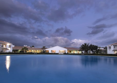 Una piscina al aire libre de temporada, sillones reclinables de piscina