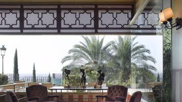 Un espace de détente intérieur avec vue sur les palmiers et le paysage urbain.