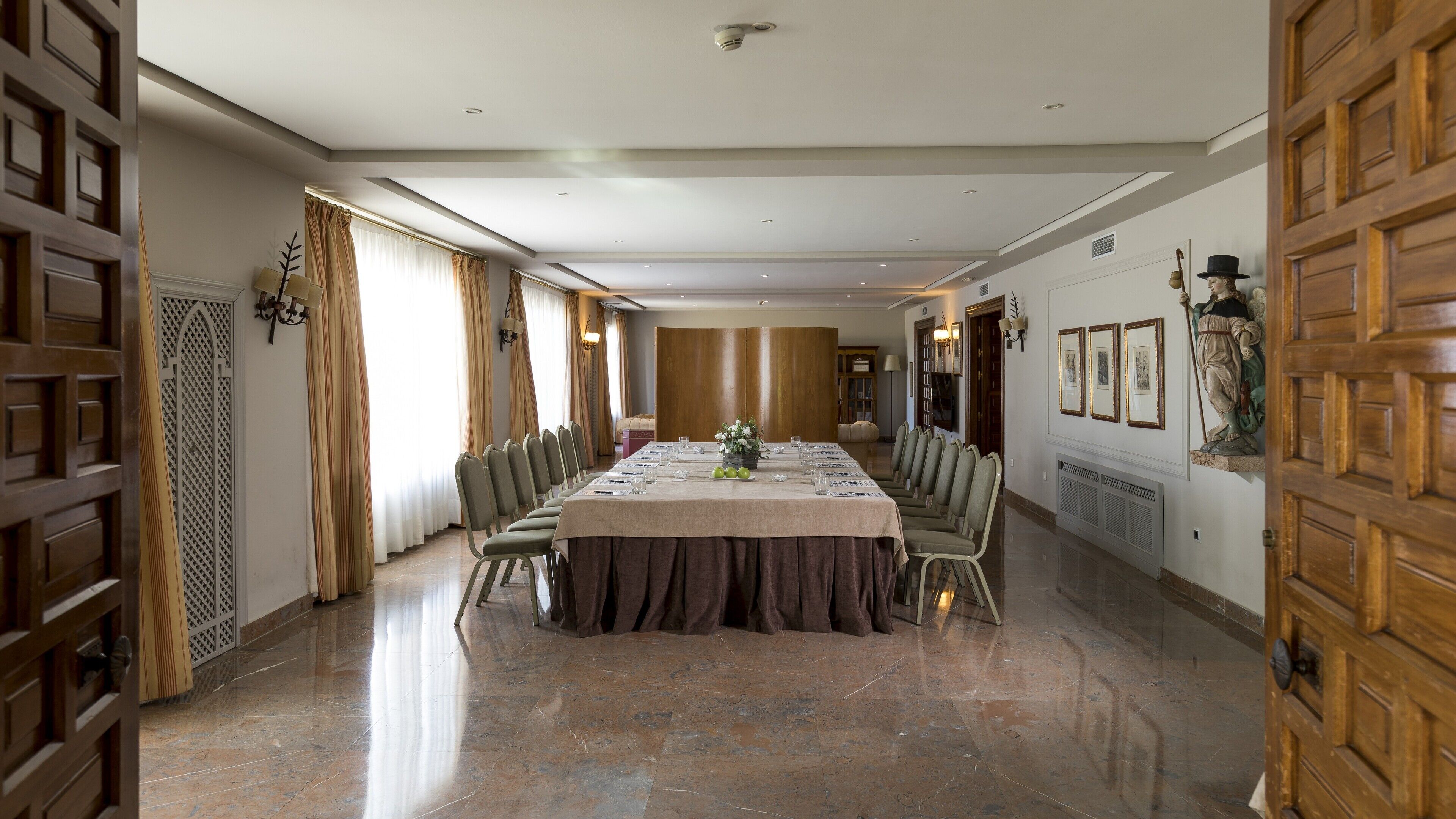 A spacious conference room with a long table, chairs, and a chandelier.