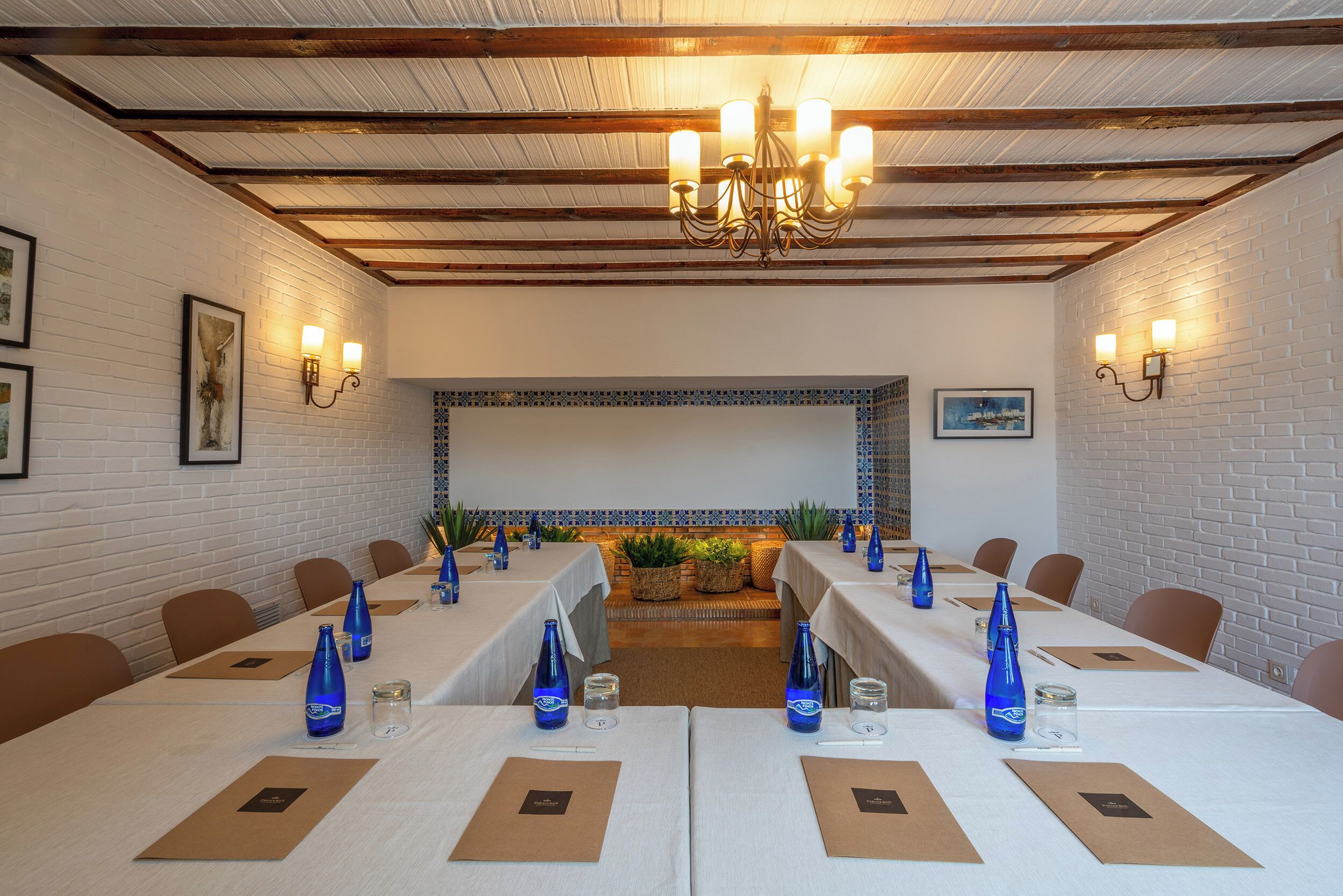 A conference room with long tables, blue water bottles, and brown name cards.