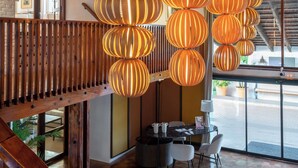 Un interior espacioso con techo alto, vigas de madera y una escalera que conduce a un nivel superior.