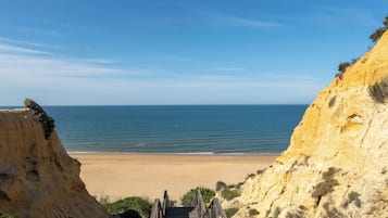 Am Strand, weißer Sandstrand, Sonnenschirme, Strandtücher