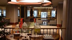 A hotel lobby with a round table featuring glassware and a Christmas tree. - Palan Hotel (Erzurum)