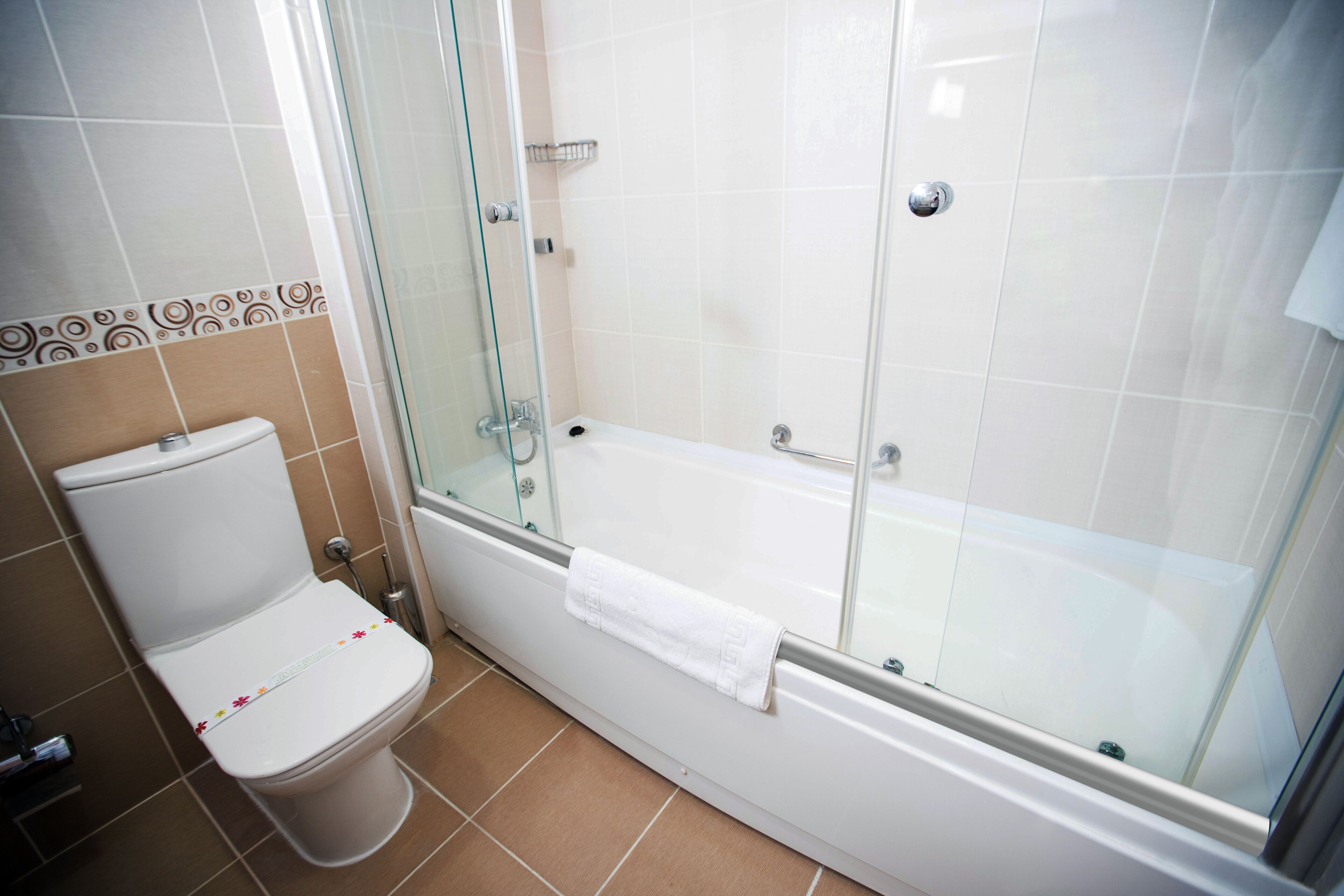 Un baño con inodoro, ducha envuelta en vidrio y bañera.