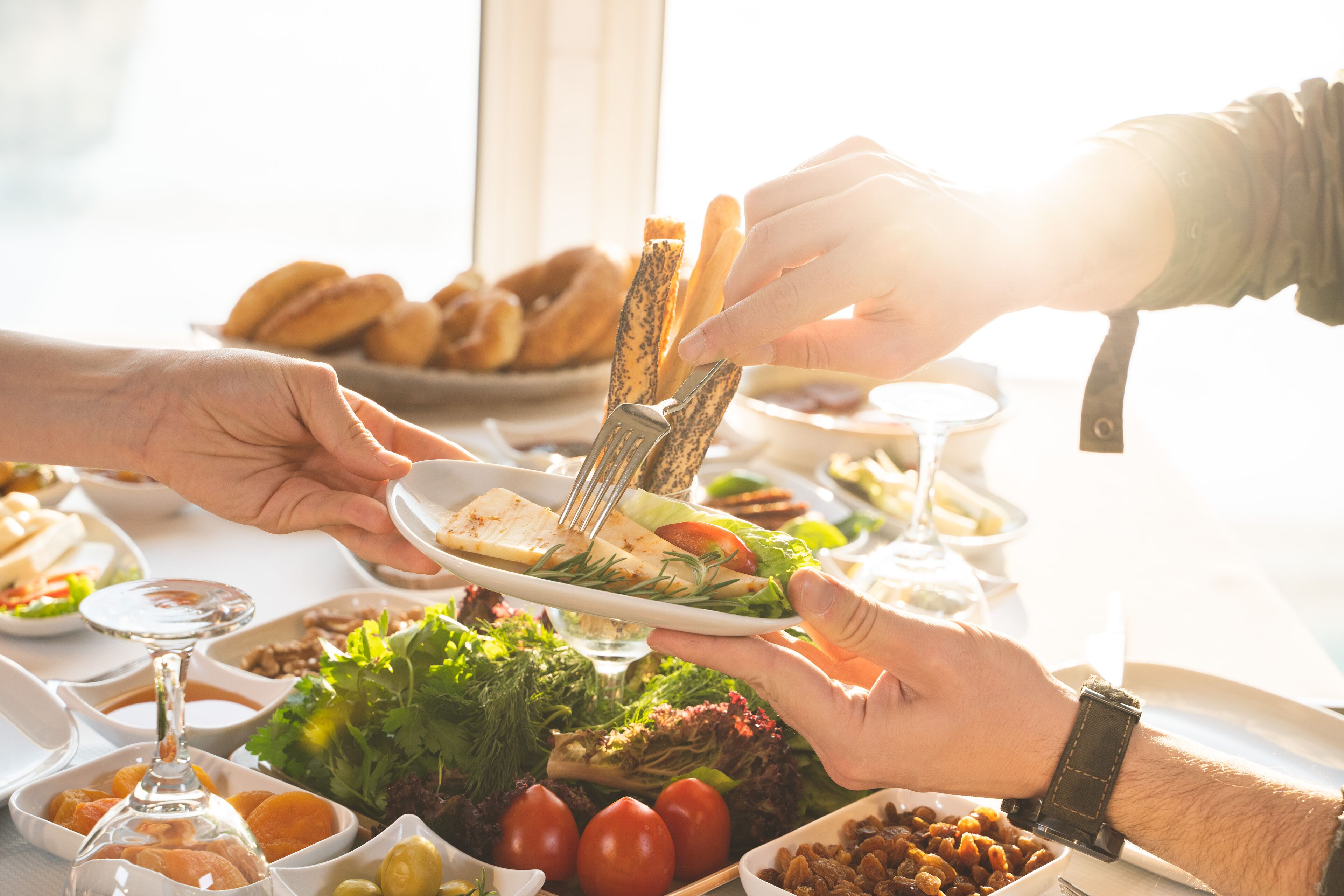 Ein Esstisch mit verschiedenen Gerichten, darunter ein Salat, Brot und Beilagen.