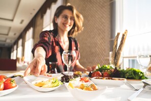 A dining table with various dishes, a wine glass, and a fork. - Orucoglu Thermal Resort (Afyonkarahisar)