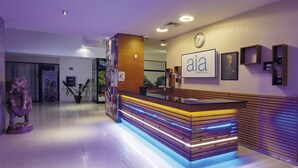 A reception area with a modern counter, a clock, and a spa wellness sign.