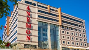 A multi-story building with a prominent "ANEMON" sign on the facade.