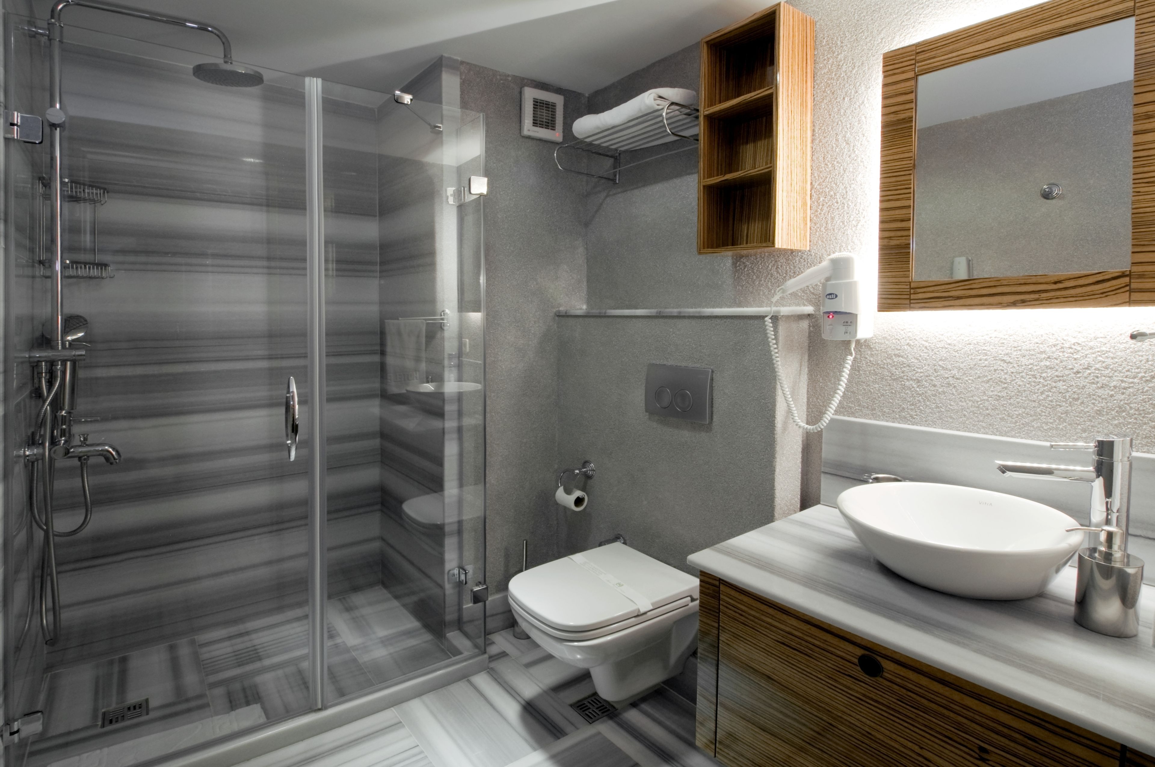 A modern bathroom with a glass-enclosed shower, a toilet, and a vanity with a sink.