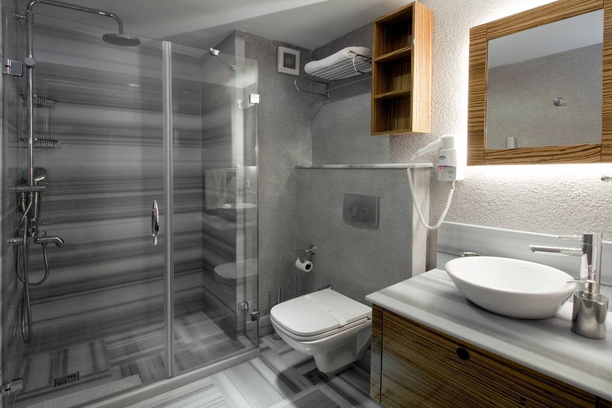 Ein modernes Badezimmer mit einer Duschkabine, einer Toilette und einem Waschtisch.