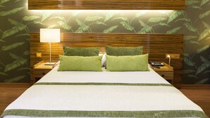 A neatly made bed with green pillows, a bedside lamp, and a nightstand with a phone. - Hotel Buyuk Keban (Istanbul)