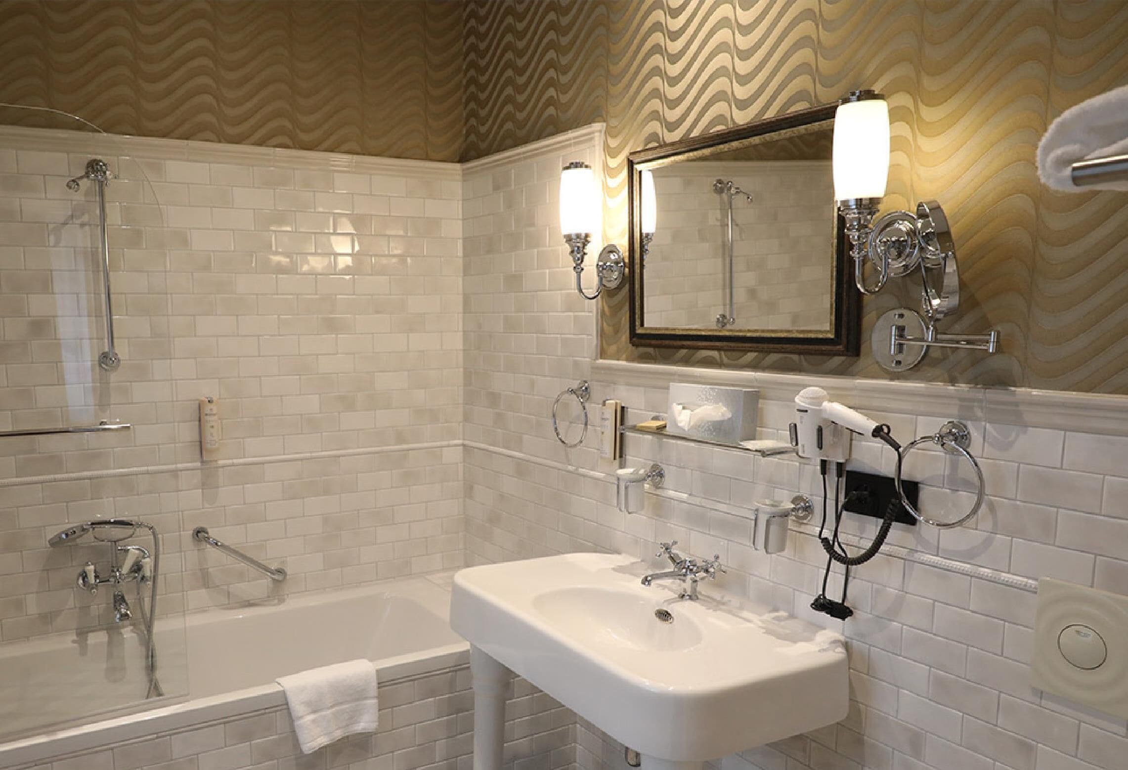 Un bagno con una vasca, un lavandino e uno specchio.