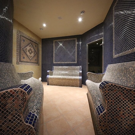 A room with two wicker chairs, a beige carpet, and a patterned wall.