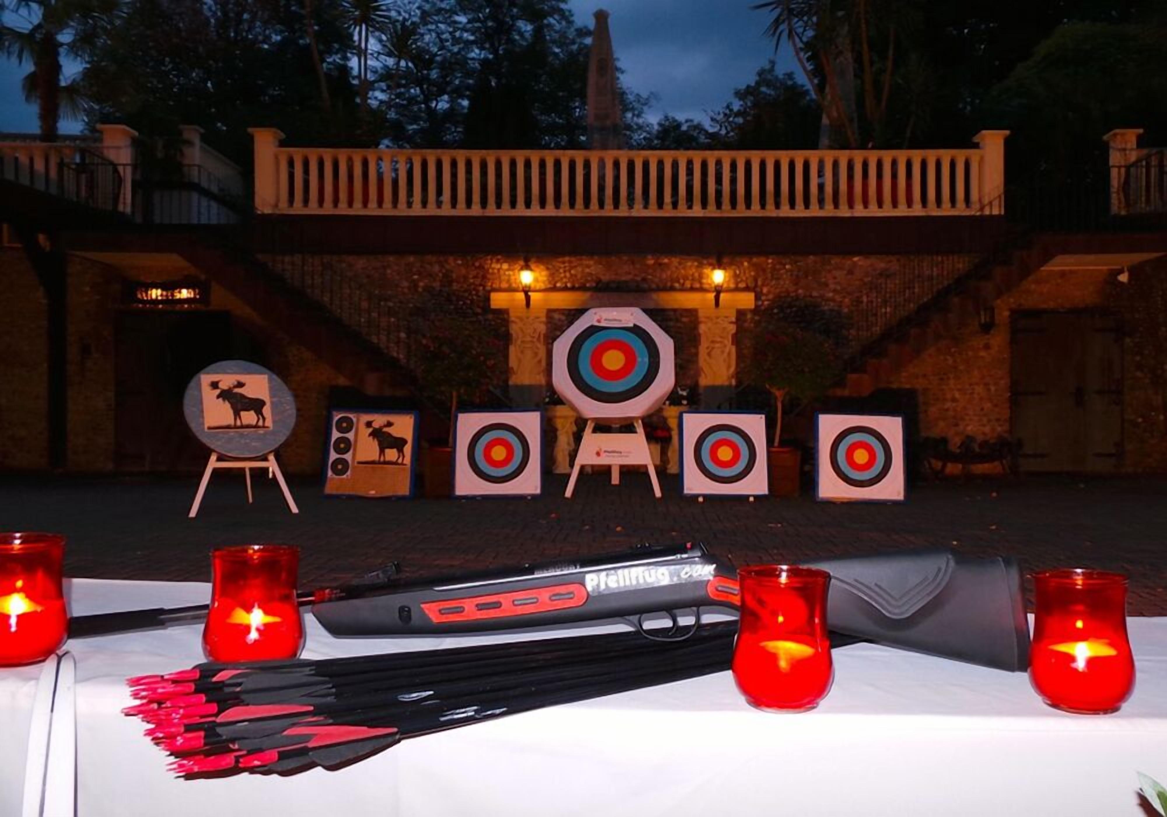 An outdoor archery setup with targets and candles.