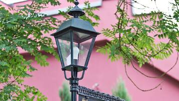 Una farola con una carcasa de cristal transparente y una parte superior decorativa.