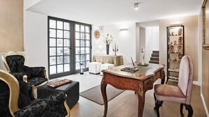A spacious living room with a large window, a dining table, and a bookshelf. - Al Canal Regio (Venice)