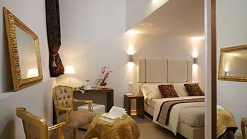 A hotel room with a bed, two chairs, a small table, and a nightstand.