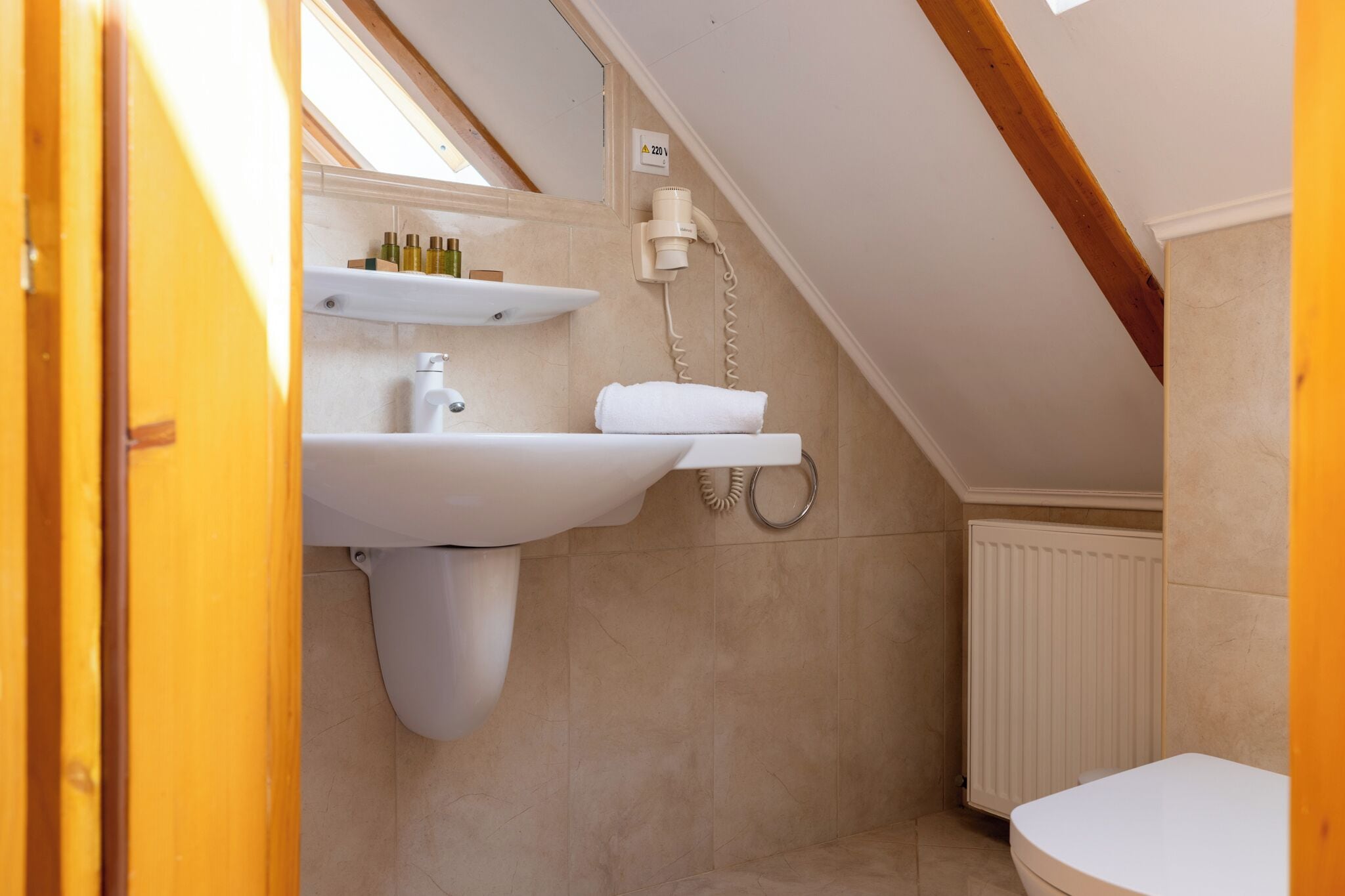 A bathroom with a white sink, a towel, and a shower.