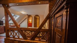 A wooden staircase with a brick base leading to a loft area with skylights. - Casa Wagner Brasov (Brasov)