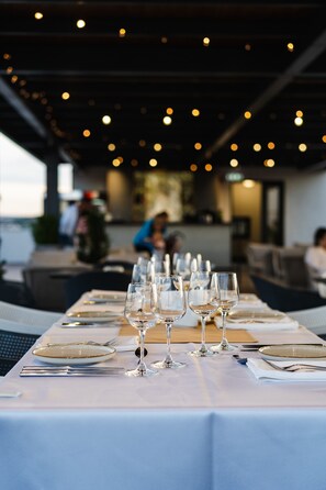 A restaurant table set with wine glasses, plates, and cutlery. - Hotel Tarnava (Odorheiu Secuiesc)