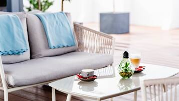 Relax in a serene outdoor space with a comfortable sofa and a small table for your drink.