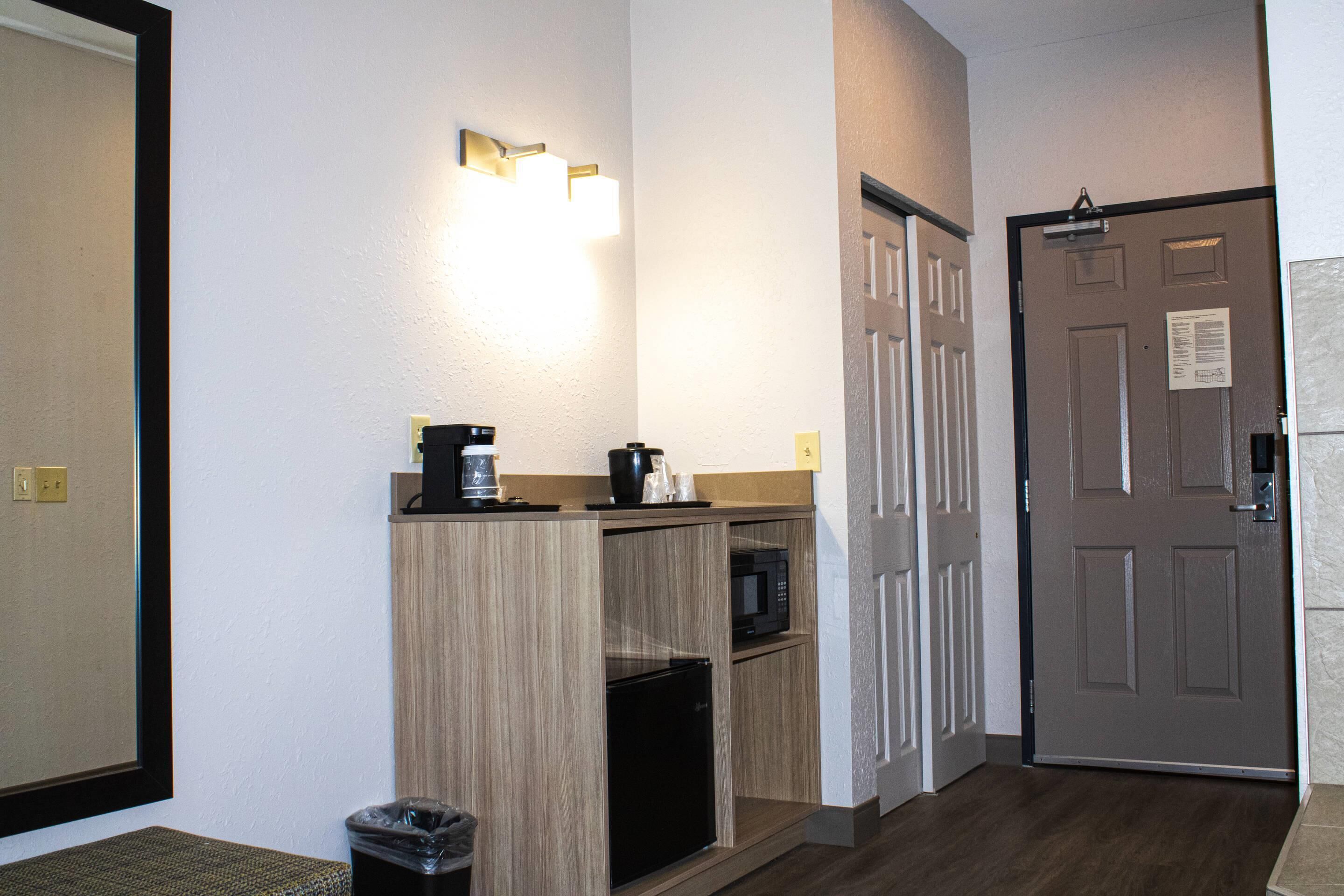 Ein Hotelzimmer mit Küchenzeile, einer Mikrowelle, einer Kaffeemaschine und einem Mülleimer.
