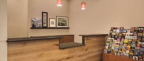 Una recepción con detalles de madera, cuadros en la pared y un atril para revistas.