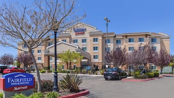 Experience the comfort of this hotel, featuring a spacious parking area and lush greenery.