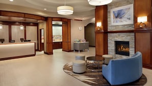 A hotel lobby with a reception desk, seating area, and a fireplace. - Homewood Suites by Hilton Fort Smith (Fort Smith)
