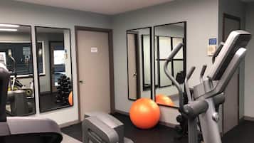 A gym with exercise equipment, a mirrored wall, and a door labeled "Equipment Room".