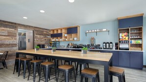 A modern kitchen with a wooden island, bar stools, and a coffee station. - The Coho Oceanfront Lodge (Lincoln City)